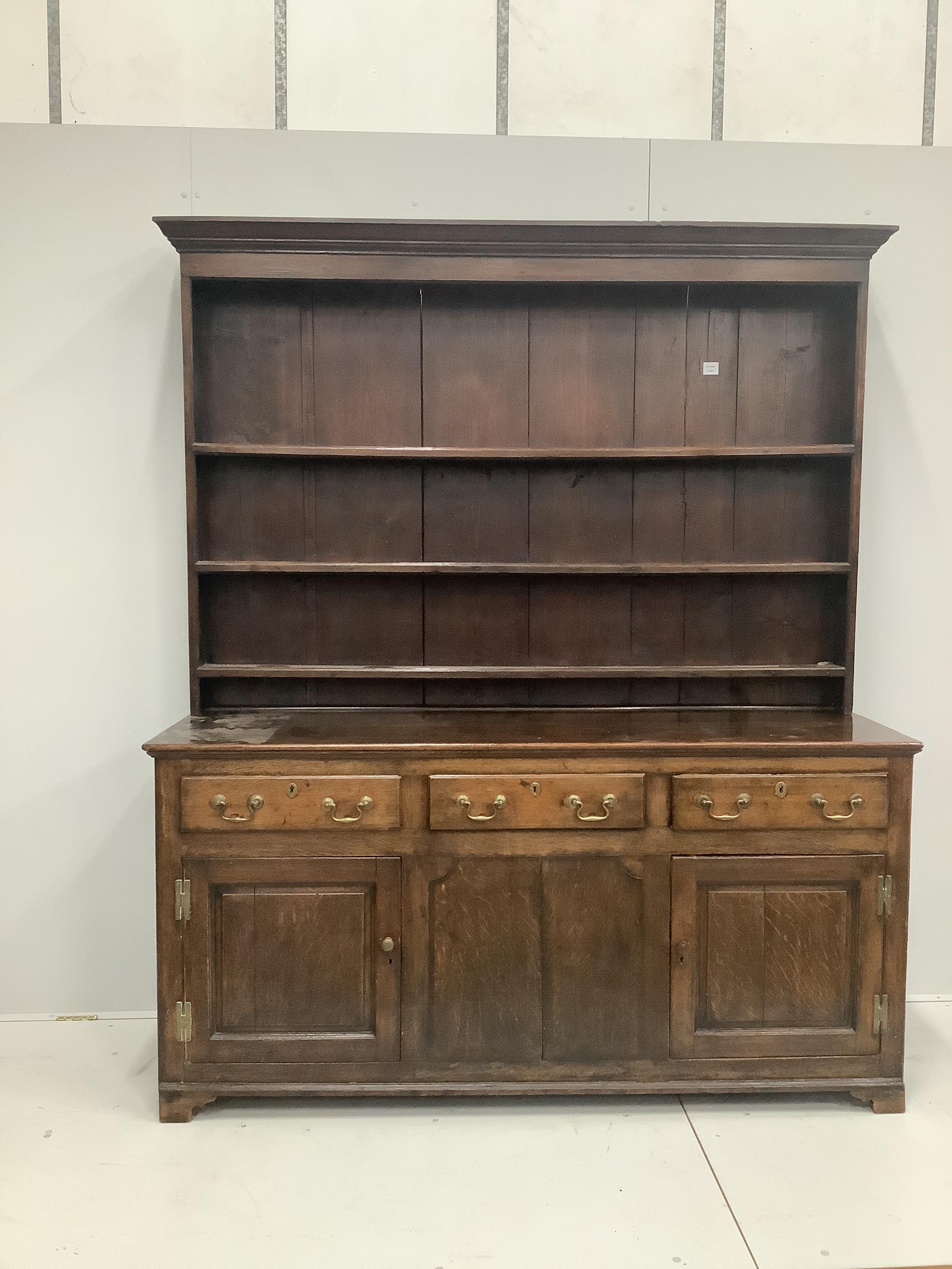 A late 18th century oak dresser base with associated rack, width 183cm, height 210cm